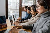 A group of professionals collaborating in an office setting, engaging in customer support.